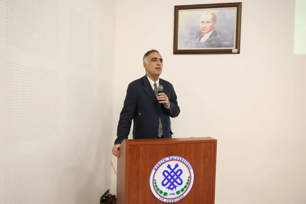Fakülte amblemli kürsüde konuşan Dekan Prof. Dr. Murat Ünal; arkada Atatürk portresi